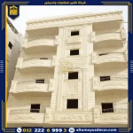 تشطيب واجهة مبنى متعدد الطوابق بحجر هاشمي 80 مع كرانيش وبراويز وحليات كلاسيكية حول الشبابيك والبلكونات